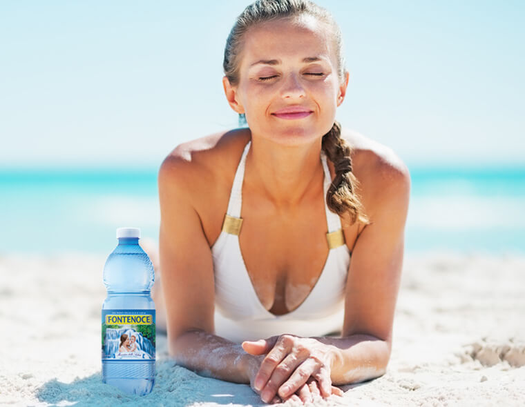 donna su spiaggia e bottiglia Fontenoce