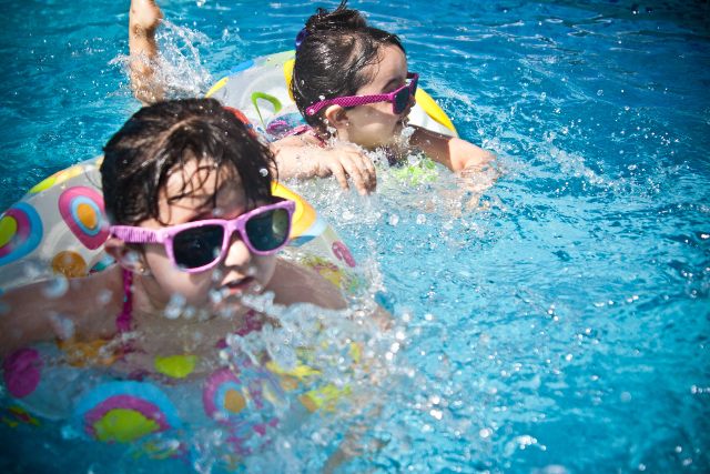 bambine in acqua con occhiali da sole