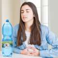 donna acidità stomaco e bottiglia di acqua fontenoce