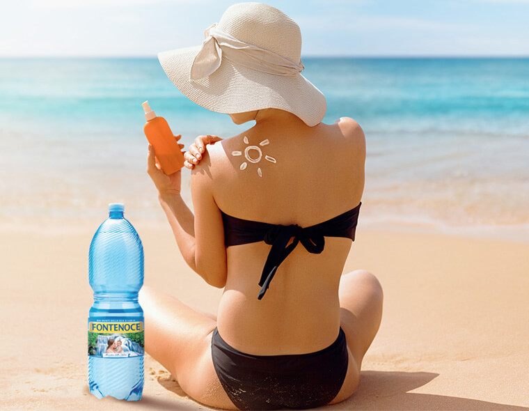 donna in spiaggia si abbronza idratandosi con bottiglia acqua fontnoce