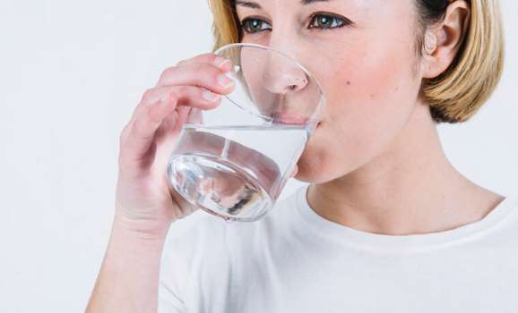 donna beve bicchiere acqua