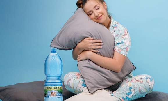 donna in pigiama con bottiglia acqua fontenoce