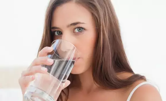 donna beve acqua per idratarsi