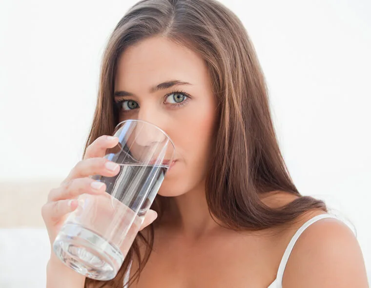 donna beve acqua per idratarsi