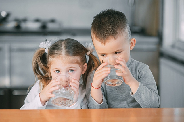 bambini bevono acqua per idratarsi