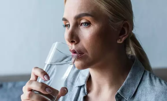 donna beve acqua per ridurre stress