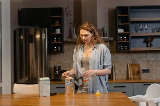 donna prepara latte artificiale biberon